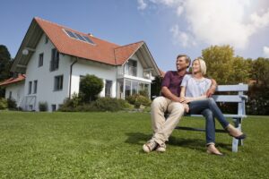 Comment choisir un banc de jardin tendance ? couple installé dans son jardin sur un banc