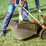 Jardinier travaillant avec une tondeuse à gazon dans le jardin